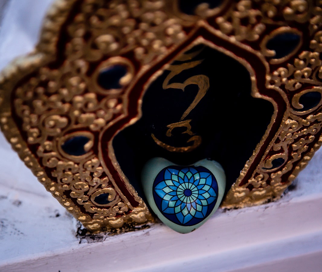Ornamental piece with gold margin and a blue heart shaped stone in the middle.